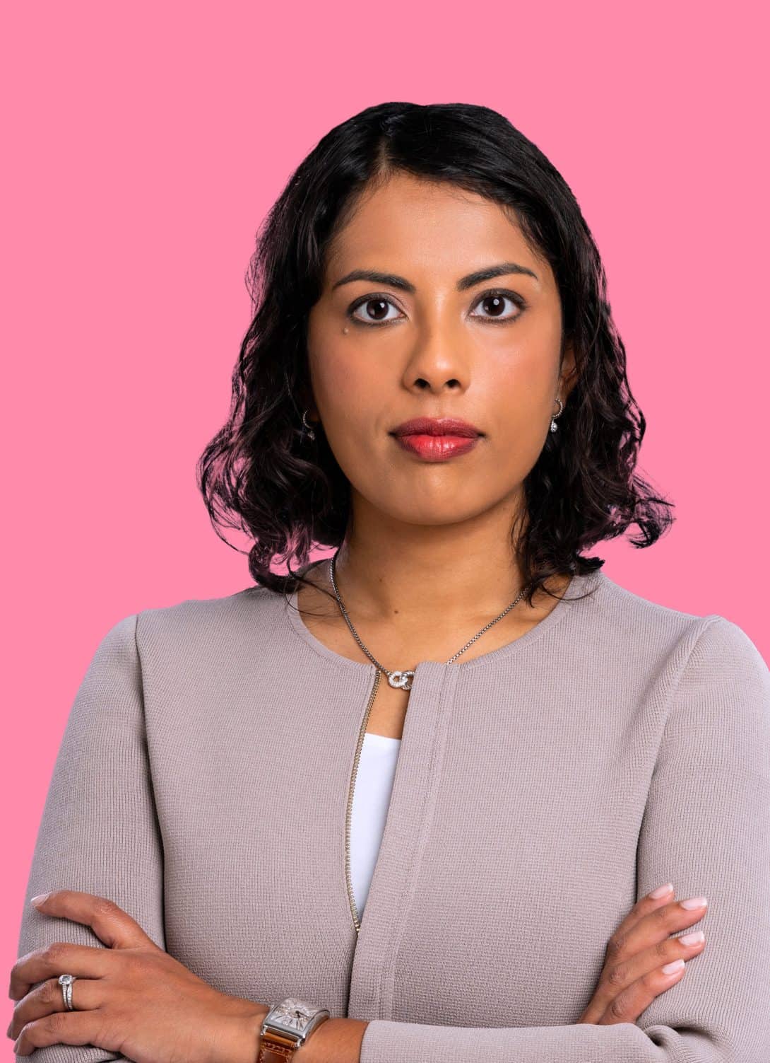 Joanna Ghosh, founder of lady justice looking at camera with arms crossed, wearing a tan blazer with jewelry