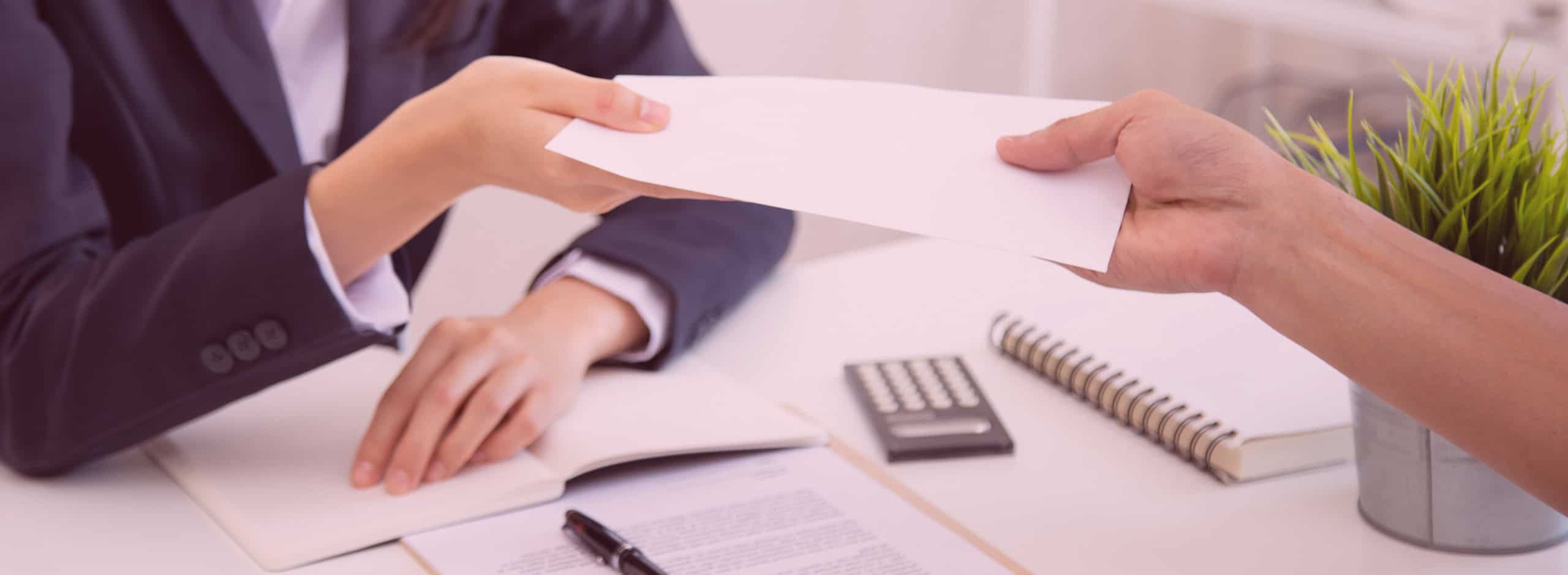 Employer handing check to employee for workers comp at a desk