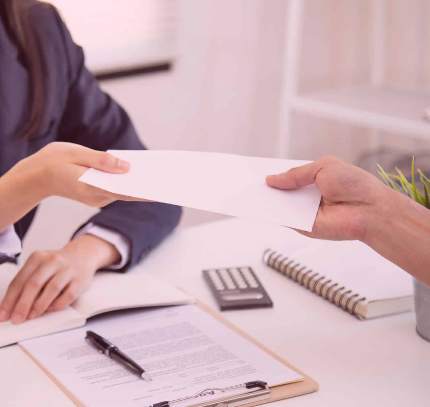 Employer handing check to employee for workers comp at a desk